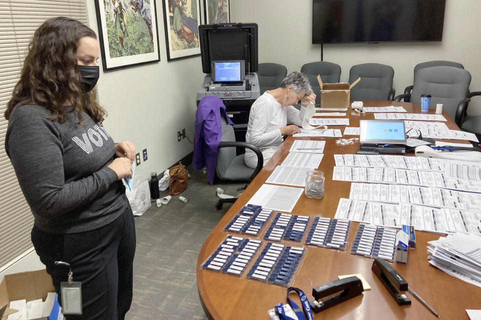 Rachel Rodriguez, left, the elections management specialist for Dane County, Wis., looks over a table of ballots being tested before being sent to more than 200 voting locations across the state's second-largest county on Sept. 14, 2022, in Madison, Wis. Her office is among those that have been hammered with requests by what appear to be coordinated campaigns by groups who reject the results of the 2020 presidential election. (AP Photo/Scott Bauer)