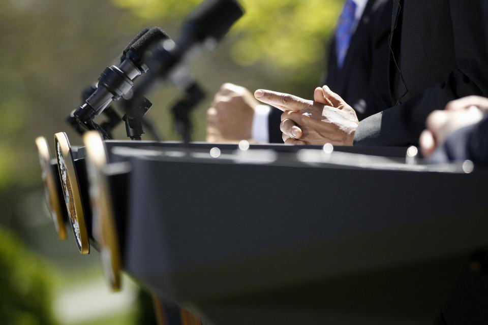 The hands of President Barack Obama, center, are seen at the podium during his joint news conference with Mexico's President Felipe Calderon, left, and Canada's Prime Minister Stephen Harper, Monday, April 2, 2012, in the Rose Garden at the White House in Washington. (AP Photo/Charles Dharapak)