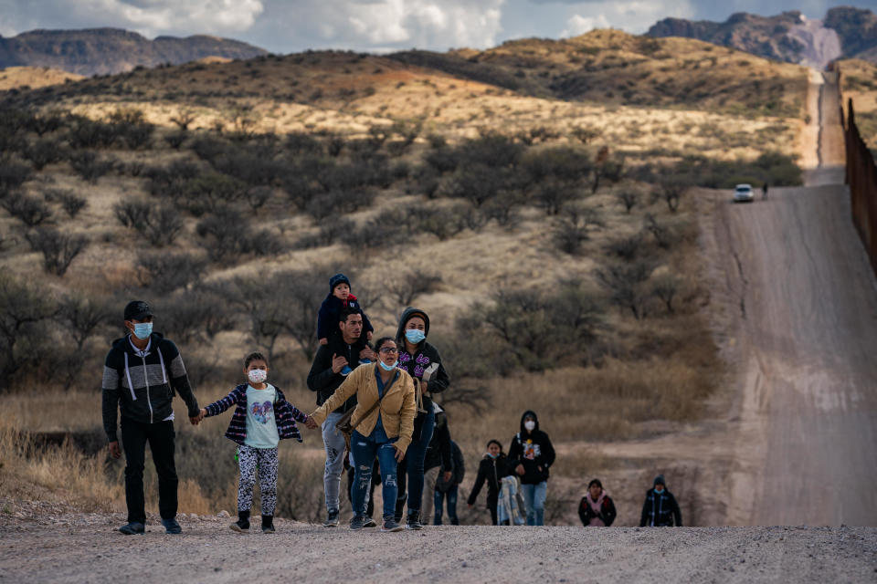 A group of migrant families from Central America walk alongside the border wall between the U.S. and Mexico after crossing into the U.S. near the city of Sasabe, Arizona, on Sunday, January 23, 2022.  / Credit: Salwan Georges/The Washington Post via Getty Images