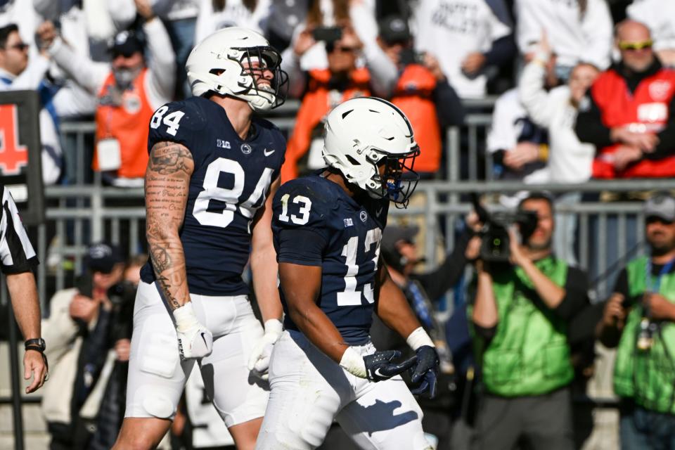 Penn State running back Kaytron Allen (13) and tight end Theo Johnson (84) celebrate a touchdown during the second half of an NCAA college football game against Ohio State, Saturday, Oct. 29, 2022, in State College, Pa. (AP Photo/Barry Reeger)