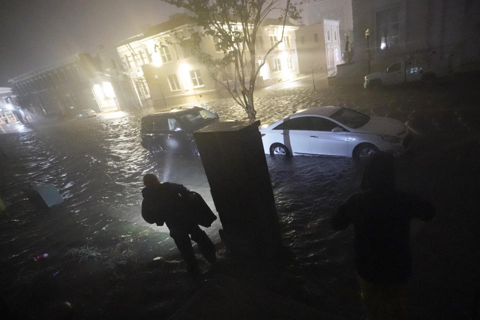 People use flashlights as they walk on flooded streets in search of their vehicle, Wednesday, Sept. 16, 2020, in Pensacola, Fla. Hurricane Sally made landfall Wednesday near Gulf Shores, Alabama, as a Category 2 storm, pushing a surge of ocean water onto the coast and dumping torrential rain that forecasters said would cause dangerous flooding from the Florida Panhandle to Mississippi and well inland in the days ahead. (AP Photo/Gerald Herbert)