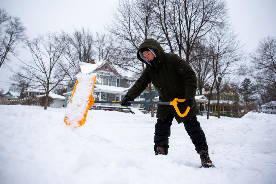Kevin Timmer-Sanchez shovels snow off his driveway after a winter storm in Holland.