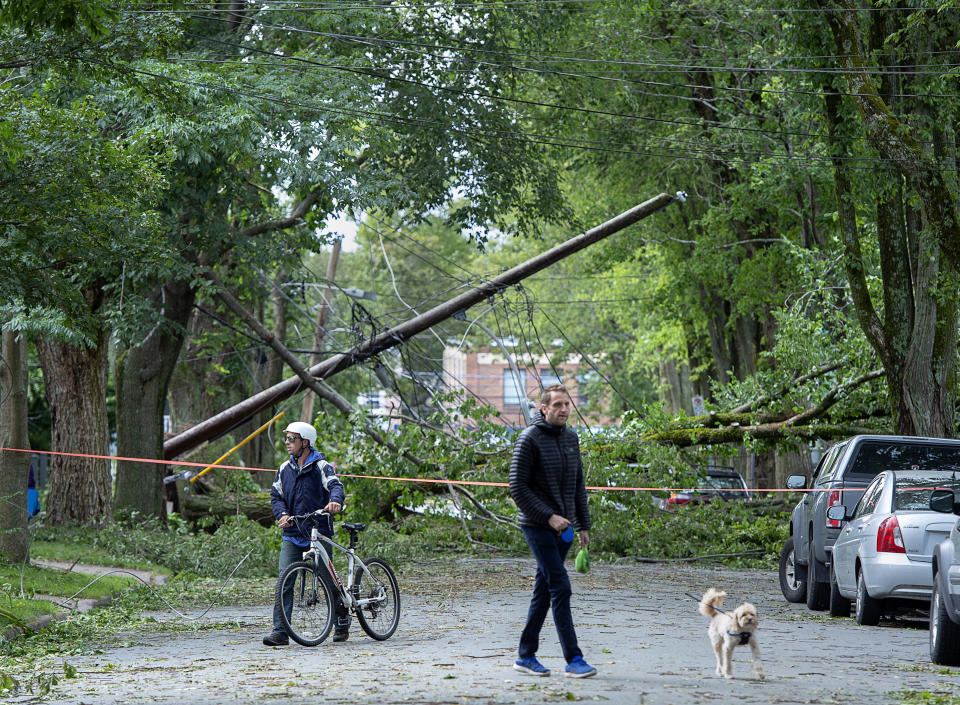 A street is blocked by fallen trees as a result of Hurricane Dorian pounding the area with heavy rain and wind in Halifax, Nova Scotia, on Sunday, Sept. 8, 2019. Hurricane Dorian brought wind, rain and heavy seas that knocked out power across the region, left damage to buildings and trees as well as disruption to transportation. (Andrew Vaughan/The Canadian Press via AP)