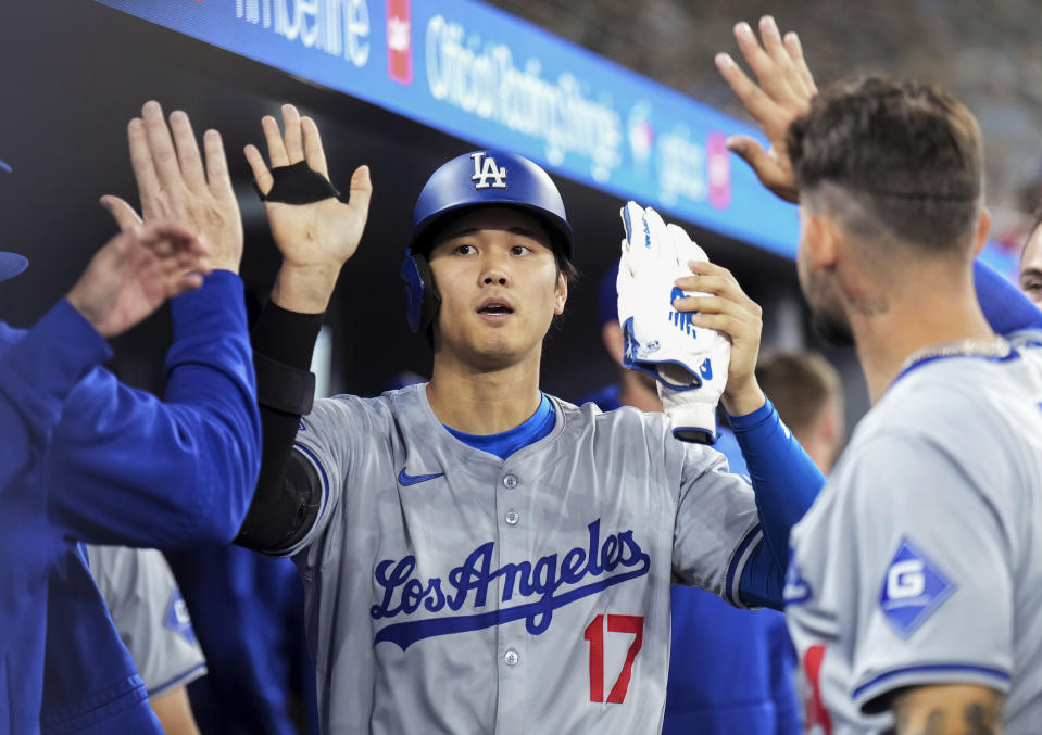 Los Angeles Dodgers designated hitter Shohei Ohtani (17) celebrates with teammates in the dugout after scoring against the Toronto Blue Jays during the third inning of a baseball game Friday, April 26, 2024, in Toronto. (Nathan Denette/The Canadian Press via AP)