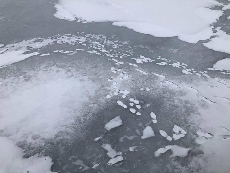 Foot steps remain Monday where they'd melted and refrozen on Stone Lake in Cassopolis.