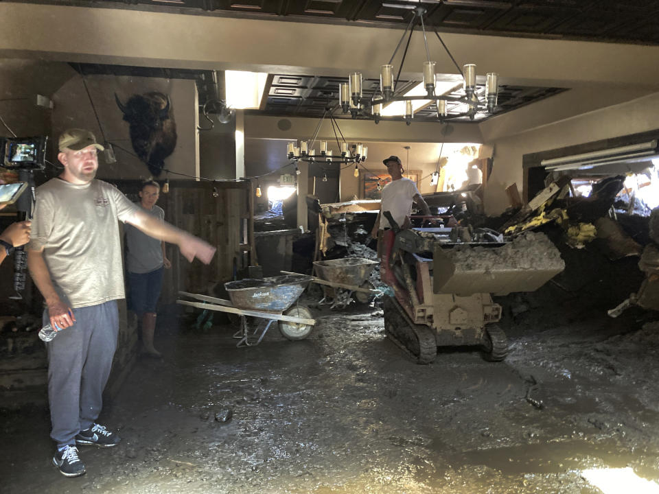 Brandon Gallegos, left, whose family owns the Oak Glen Steakhouse and Saloon, shows the level of the mudslide damage inside the Oak Glen Steakhouse and Saloon in Oak Glen, Calif., on Wednesday, Sept. 14, 2022. (AP Photo/Amy Taxin)
