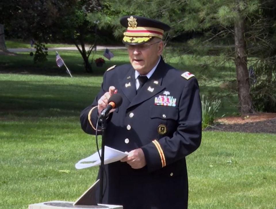 In this image captured from Hudson Community Television, retired Army Lt. Col. Barnard Kemter checks to see if the microphone is functioning after organizers turned off audio during a portion of his Memorial Day speech Monday, May 31, in Hudson, Ohio.