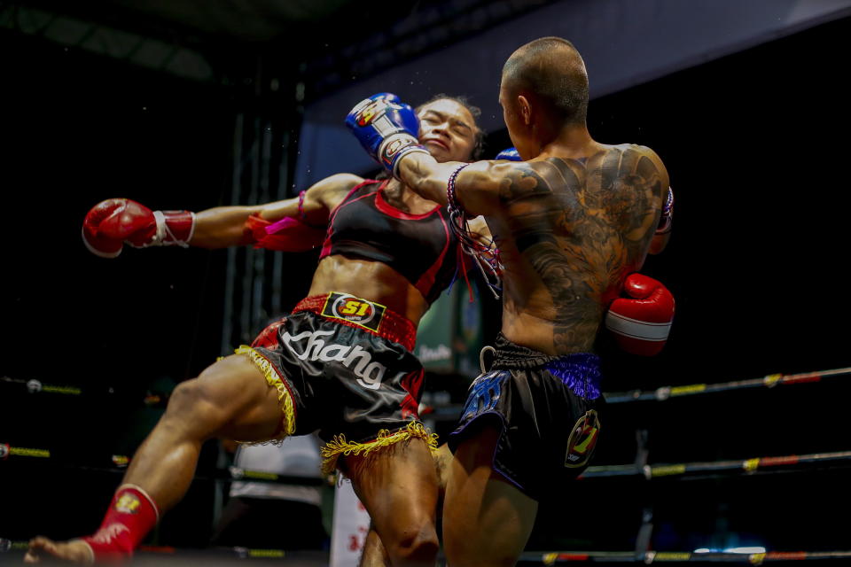 DAZ021. PHIMAI (TAILANDIA), 26/09/2018.- La luchadora transgénero de Muay Thai, Nong Rose (i), se enfrenta a Saangdawan (d) en el templo Wat Derm en Phimai, provincia de Nakhon Ratchasima, (Tailandia), el 20 de septiembre de 2018. Nong Rose, actualmente la única luchadora transgénero activa de Muay Thai, sigue los pasos de Nong Toom, la primera luchadora transgénero. Nong Toom logró romper con las reglas conservadoras de este deporte antiguo y optó por retirarse de las peleas en 1999 para someterse a la cirugía de reasignación de género. Vestida con pantalones cortos de Muay Thai, un sujetador deportivo y un forro de cejas y lápiz labial rojo, Nong Rose, de 22 años, sube al ring decidida a luchar no solo contra sus oponentes masculinos sino también contra la discriminación. EFE/DIEGO AZUBEL