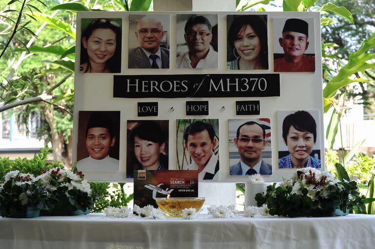 Un póster con los tripulantes del vuelo MH370 puesto para acompañar una oración colectiva en una escuela de Petaling Jaya (Archivo)