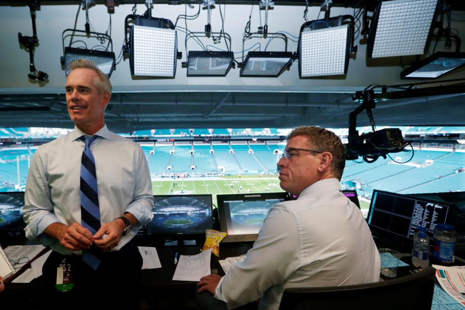 FILE - Fox Sports play-by-play announcer Joe Buck, left, and analyst Troy Aikman work in the broadcast booth before a preseason NFL football game between the Miami Dolphins and Jacksonville Jaguars in Miami Gardens, Fla., Aug. 22, 2019. On Monday, May 16, 2022, Buck and Aikman made their first trips to ESPN headquarters in Bristol, Connecticut, to meet with executives and their future co-workers as preparations for the upcoming season began to ramp up. (AP Photo/Lynne Sladky, File)