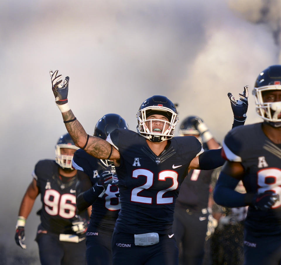 Connecticut linebacker Eli Thomas (22) raises his arms to the crowd as his team enters the field for a game against Central Florida on Thursday, Aug. 30, 2018, in East Hartford, Connecticut. (AP Photo/Stephen Dunn)