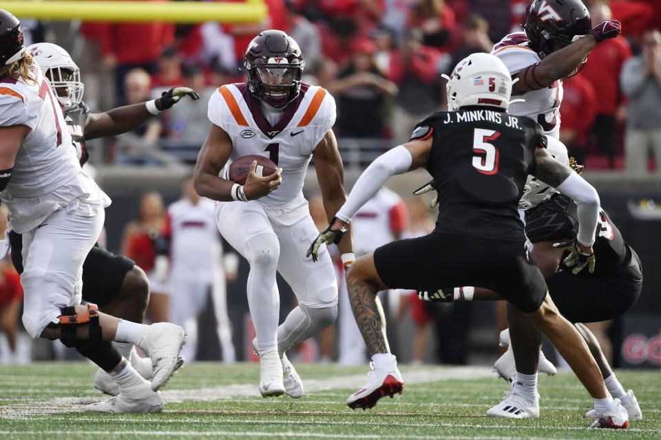 Virginia Tech quarterback Kyron Drones (1) attempts to avoid the defense of Louisville defensive back Josh Minkins (5) during the first half of an NCAA college football game in Louisville, Ky., Saturday, Nov. 4, 2023. Louisville won 34-3. (AP Photo/Timothy D. Easley)