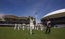 Australia's Mitchell Johnson (front) acknowledges the crowd with his cap after taking seven wickets in the inning as the team walks off the field at the end of England's inning during the third day of the second Ashes test cricket match at the Adelaide Oval December 7, 2013.