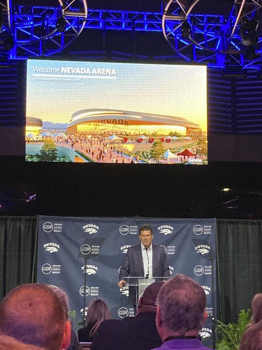 Nevada basketball coach Steve Alford speaks at news conference with a rendering of the school's planned, future arena displayed above, Wednesday, Sept. 27, 2023, in Reno, Nev. The University of Nevada’s basketball team could have a new off-campus home by 2026 under an ambitious 10-year expansion plan that Reno’s largest hotel-casino has in the works. (AP Photo/Scott Sonner)