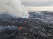 An eruptive fissure spews lava and smoke from a volcano in Grindavik, Iceland, Wednesday, May 29, 2024. A volcano in southwestern Iceland erupted Wednesday for the fifth time since December, spewing red lava that once again threatened the coastal town of Grindavik and led to the evacuation of the popular Blue Lagoon geothermal spa. (AP Photo/Marco di Marco)