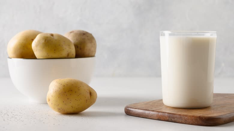 Bowl of potatoes beside glass of milk