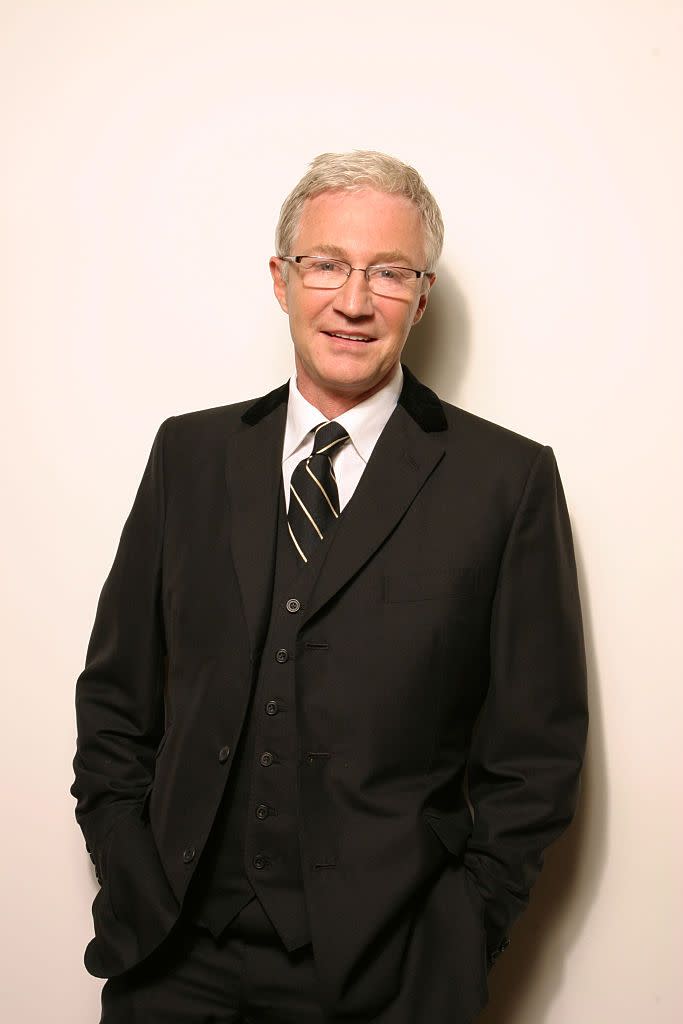 english comedian and television presenter paul ogrady, wearing a black suit and glasses