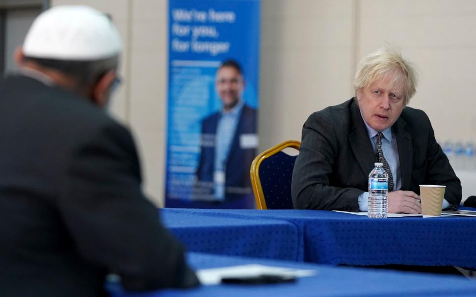 Boris Johnson speaks to members of staff as he visits a COVID-19 vaccination centre in Batley, West Yorkshire, - AP Pool