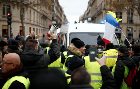 Protesters wearing yellow vests, a symbol of a French drivers' protest against higher fuel prices, block the street in Paris, France, November 24, 2018. REUTERS/Benoit Tessier