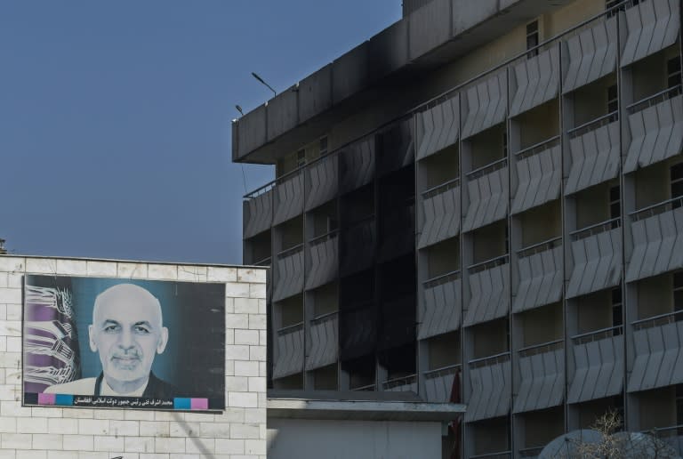 A poster bearing the image of Afghan President Ashraf Ghani is pictured next to scorch marks at the Intercontinental Hotel in Kabul following the attack