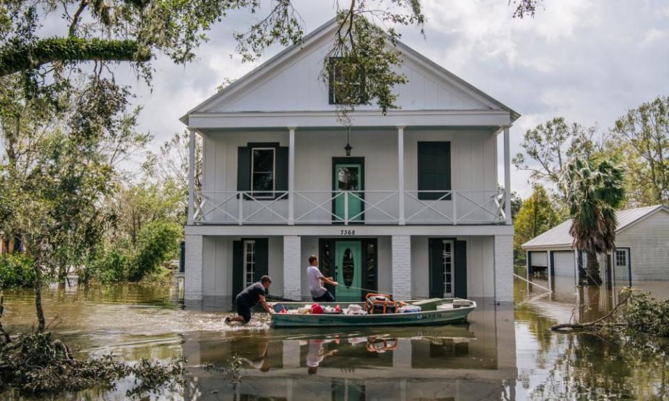 People wade through water in Barataria, Louisiana, in August after Hurricane Ida made landfall.