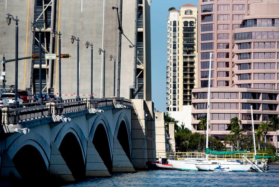 A tow boat moves a sailboat that collided with the north side of the Royal Park Bridge on Tuesday.