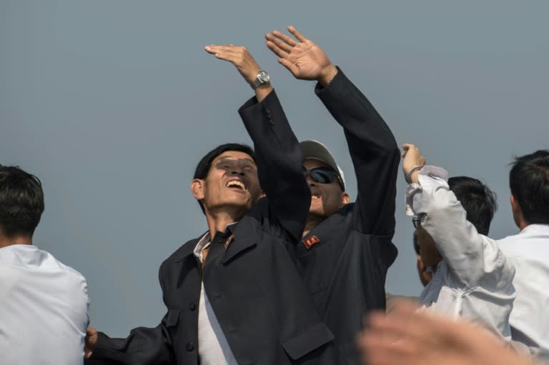 Spectators watch as a Hughes MD-500 helicopter performs a fly-by during the first Wonsan Friendship Air Festival