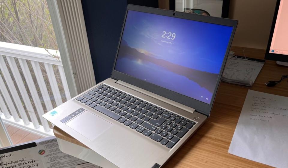 The Lenovo Ideapad 3 sitting on a desk with the Windows splash screen displayed.