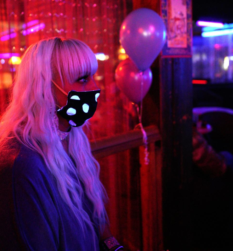  Echo, a worker at The Den strip club in Cheyenne, Wyoming, watches performers onstage during the club's reopening Friday night. The club hosted a "masks on, clothes off" party to celebrate.