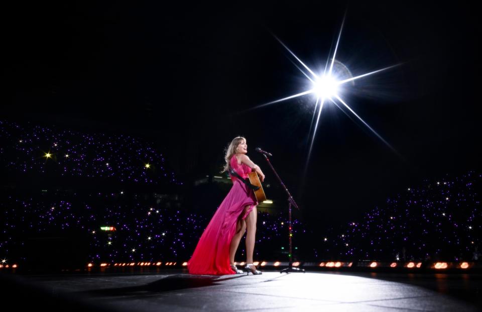 Taylor Swift sings with her guitar onstage during an Eras Tour performance on June 13, 2024, in Liverpool.