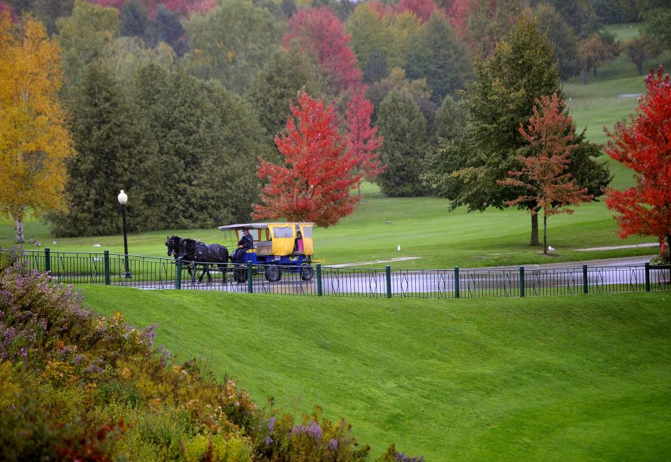 Horses pull visitors in a taxi to the Grand Hotel on Mackinac Island near the end of the tourist season in 2014.