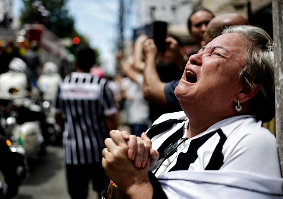 An emotional fan reacts during the procession of Pelé’s casket (REUTERS)