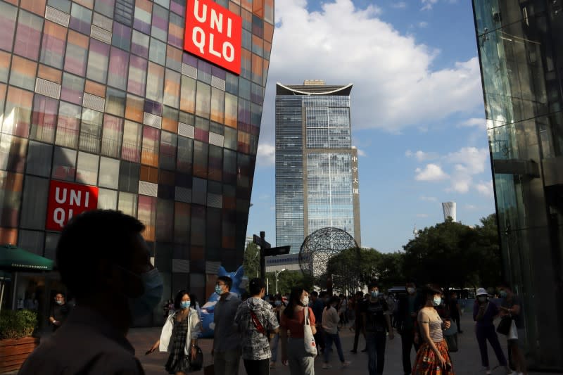 People walk past a store of the Fast Retailing's fashion chain Uniqlo, in Beijing