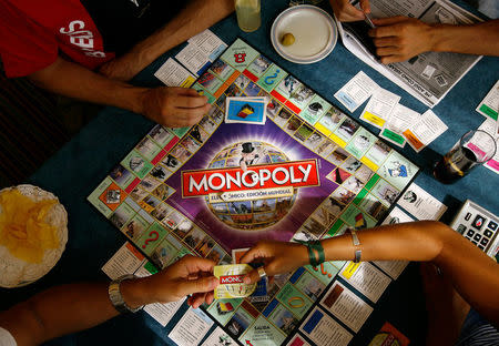 Players participate in a Guinness world record attempt taking place across the world for the largest simultaneous game of Monopoly, at a hotel in Madrid, August 27, 2008. REUTERS/Paul Hanna/File Photo