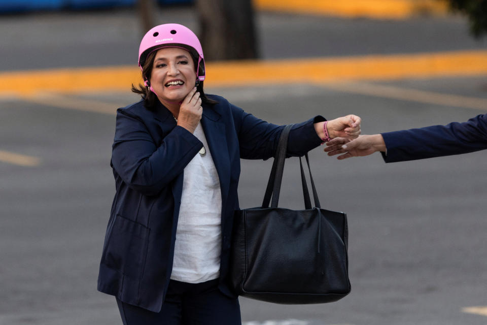 Xóchitl Gálvez, candidata presidencial de 'Fuerza y Corazón por México', una alianza de partidos de oposición, se quita el casco después de llegar en una bicicleta eléctrica para el primer debate presidencial en las instalaciones del Instituto Nacional Electoral (INE), en Ciudad de México, 7 de abril de 2024. REUTERS/Quetzalli Nicte-Ha