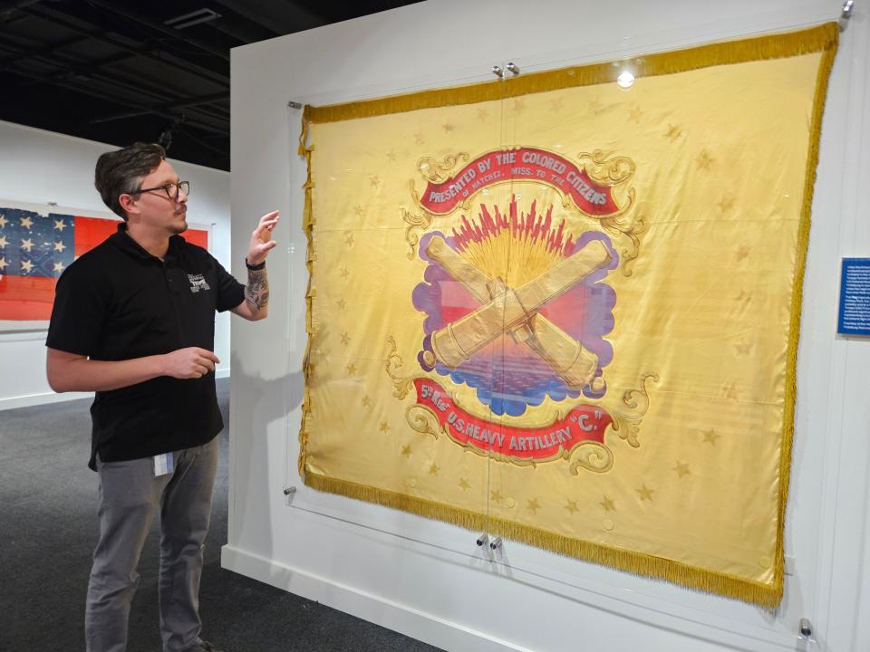 Drew Gardner, manager of family and community learning, talks about one of the flags in the "Flags From Mississippi: Emblems Through Time" exhibit on display through Nov. 8, 2024, at the Two Mississippi Museums. Admission is free.