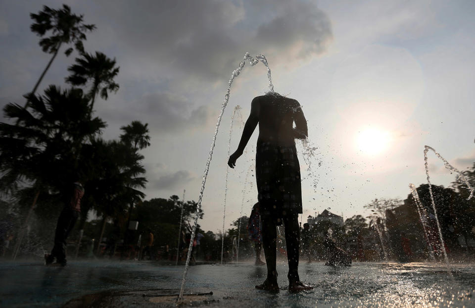 A boy plays with water fountains in Sri Lanka