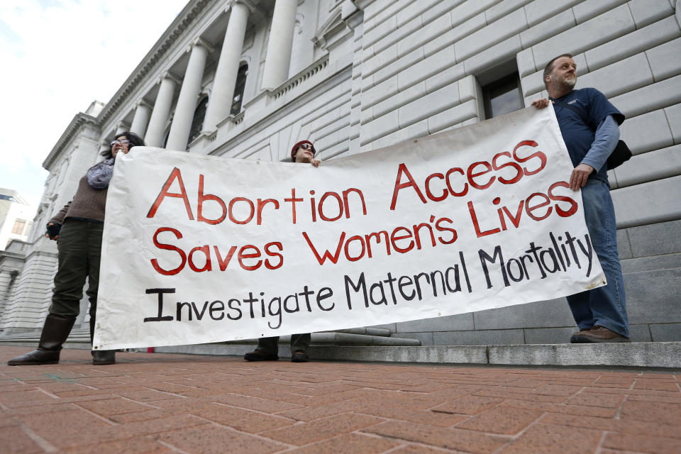 FILE - Bill Lambert, right, Phil Walk, center, and Brenda Serrato demonstrate outside of the 5th U.S. Circuit Court of Appeals on Jan. 7, 2015, in New Orleans. States with some of the nation's strictest abortion laws are also some of the hardest places to have and raise a healthy child, especially for the poor, according to an analysis of federal data by The Associated Press. (AP Photo/Jonathan Bachman, File)