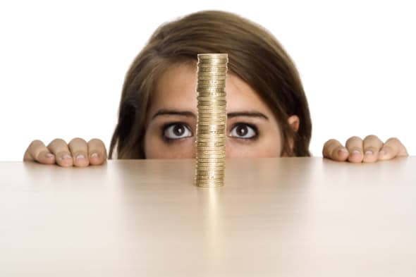 A teenage girl watching a stack of British Pound coins