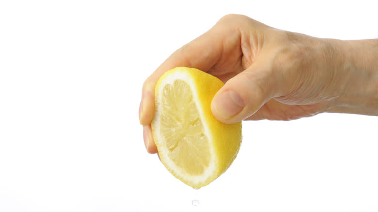 hand squeezing lemon