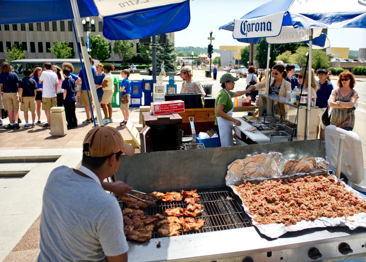 In this 2012 file photo, Alfredo Tome, left, and Linh Luong, center, prepare and serve authentic Vietnamese cuisine at the Thanh Linh food cart at the Peoria County Courthouse Plaza.