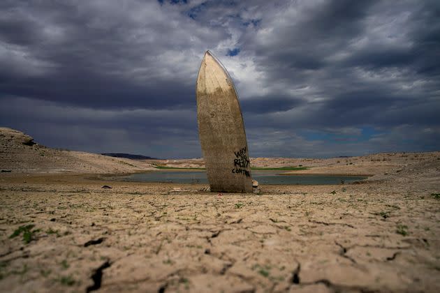 A formerly sunken boat stands upright with its stern buried in the mud along the shoreline of Lake Mead at the Lake Mead National Recreation Area on June 22, 2022, near Boulder City, Nevada.