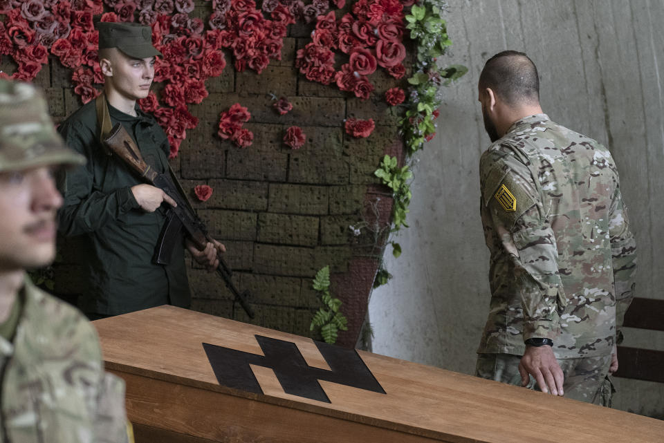 FILE - In this July 21, 2022 file photo, a soldier of the Azov regiment pays his last respects to a serviceman killed in a battle against the Russian troops in a city crematorium in Kyiv, Ukraine. Russia's Supreme Court has declared Ukraine's Azov Regiment a terrorist organization and that designation could lead to terror charges against some of the captured fighters who made their last stand inside a Mariupol shattered steel plant back in May of this year. (AP Photo/Andrew Kravchenko, File)