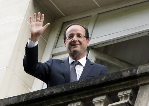 France's president-elect Francois Hollande waves from his Parisian balcony. European and world leaders have reached out to Hollande, France's first Socialist head of state in 17 years, despite jitters about his pledge to renegotiate Europe's austerity pact