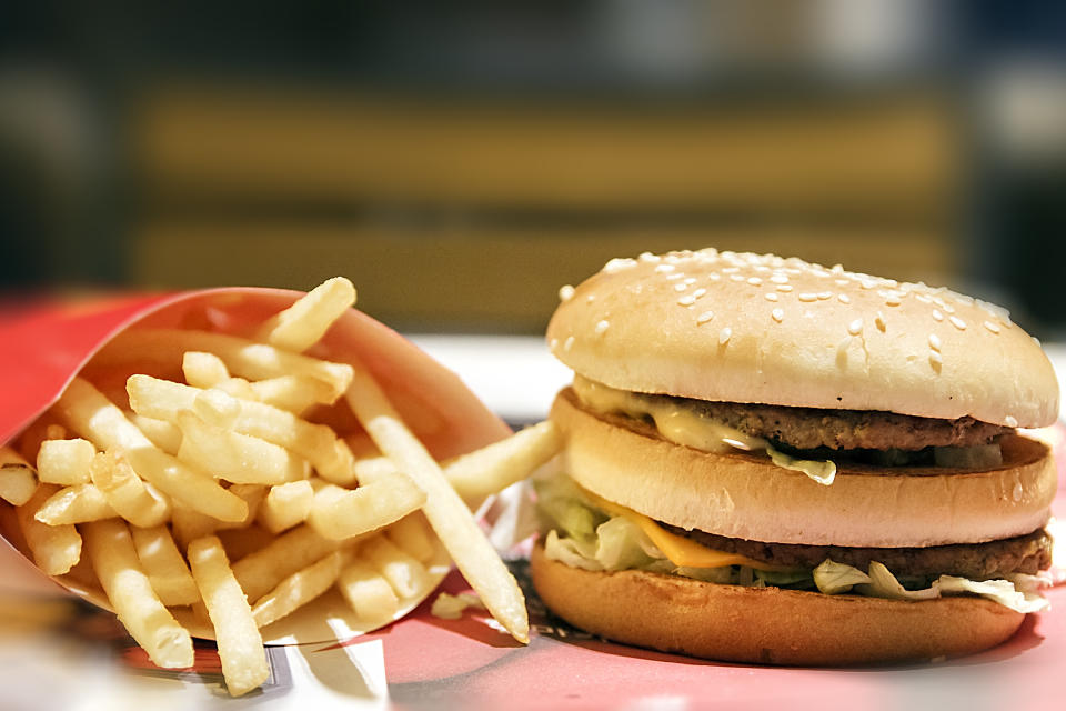 A double cheeseburger and fries in a red box.