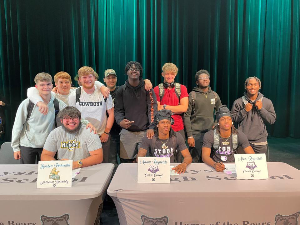 Teammates join three Bears football players who signed at Bayside High on Friday, April 5, 2024.