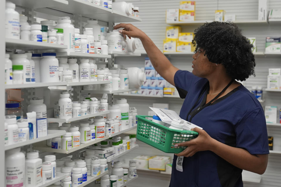 Lachandretta "LaLa" Williams reaches for a pill bottle at MAC Pharmacy, Wednesday, May 29, 2024, in Cleveland. (AP Photo/Sue Ogrocki)