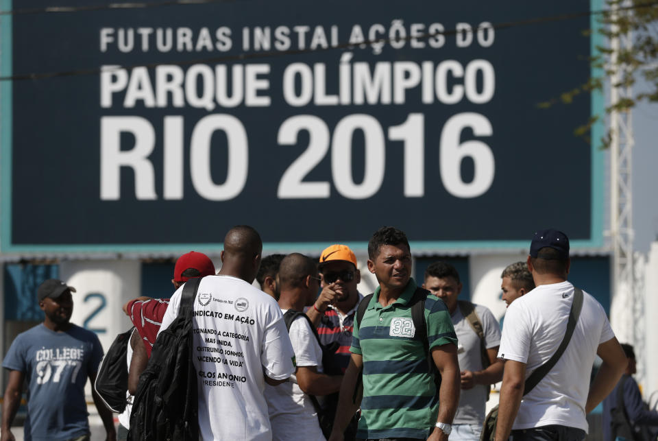 Striking workers stand in front the entrance of the Olympic Park, the main cluster of venues under construction for the 2016 Summer Olympic Games, in Rio de Janeiro, Brazil, Tuesday, April 8, 2014. The labor dispute centers around which union represents the construction workers, and also involves benefits and working conditions. (AP Photo/Silvia Izquierdo)