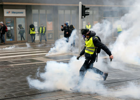 FILE PHOTO: A protester returns a tear gas canister during a demonstration of the "yellow vests" movement in Strasbourg, France, January 12, 2019. REUTERS/Vincent Kessler/File Photo