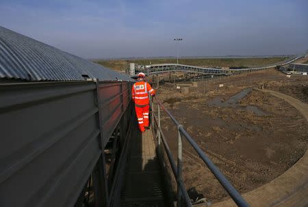 A worker walks alongside a conveyor belt carrying earth from the Crossrail project which will be used to landscape a saltwater marsh wildlife habitat on Wallasea island, in Essex, March 13, 2014. REUTERS/Andrew Winning